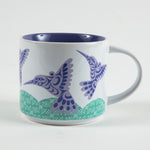 Tasse sur laquelle on voit une image de colibris