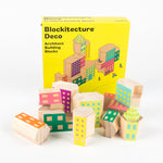 Blocs de bois de couleurs pastel devant une boîte sur laquelle on peut lire, en anglais, « Blockitecture® Deco Architect Building Blocks »