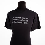 un t-shirt noir affichant le texte « All human beings are born free and equal in dignity and rights »