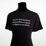 un t-shirt noir affichant le texte « Tous les êtres humains naissent libres et égaux en dignité et en droits »