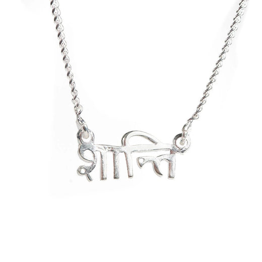 Pendentif en argent sur une chaîne; le pendentif est le mot « shanti » en sanskrit.