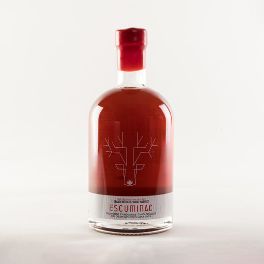 Bouteille de sirop d’érable scellée avec de la cire rouge; on voit l’illustration d’un orignal et le texte « Great Harvest, Escuminac, pure organic maple syrup, Canada Grade A / Grande récolte, Escuminac, sirop d’érable pur biologique, Canada catégorie A » sur la bouteille.