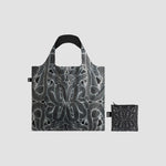 Sac posé à plat montrant un motif abstrait et moderne en noir et blanc, avec une petite pochette de transport.