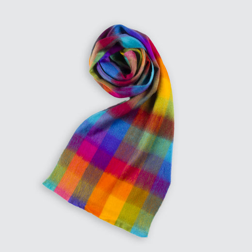 Foulard en laine d’alpaga au motif multicolore à carreaux partiellement enroulé.